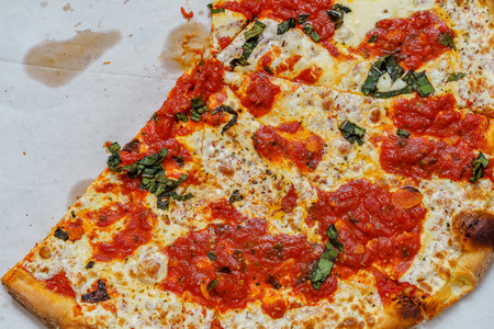 A real tasty cheese pizza from a restaurant on cardboard.の写真素材