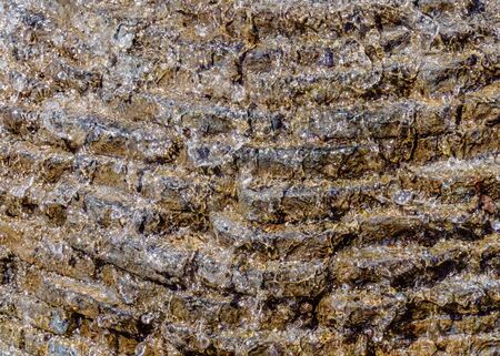 Stone masonry with running water flowing down with water foam background texture.の写真素材