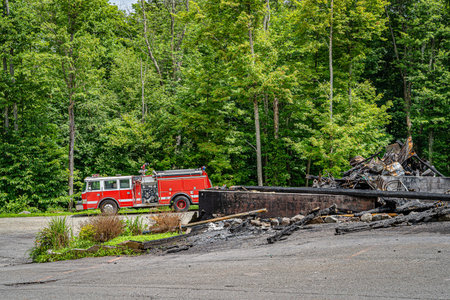Big red fire truck near the burnt out shop, fire extinguished.