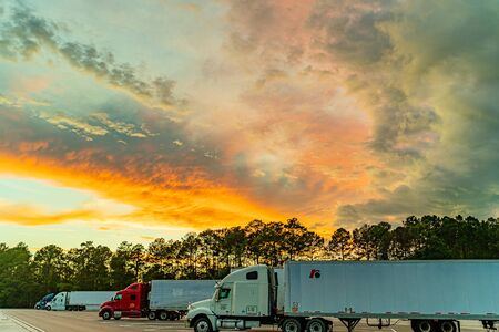 Visitor center and rest area in Georgia USA against the backdrop of a summer sunset with white, orange, blue and dark clouds in the sky and heavy truck, trailer.のeditorial素材
