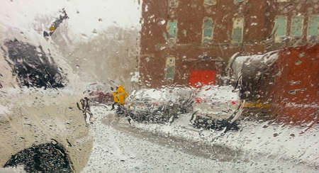 Winter storm through car window building man in yellow rancoat Brooklyn, NY USの写真素材
