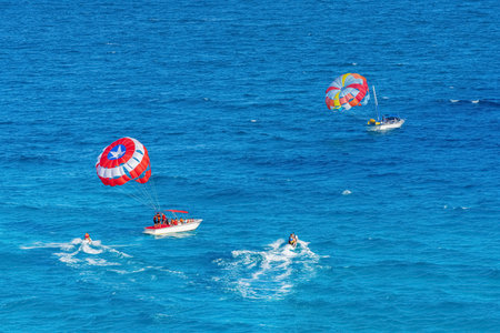 Parasailing towed behind a boat in the Caribbean sea, tropical Ocean, Vacation Concept, Cancun, Mexicoの写真素材