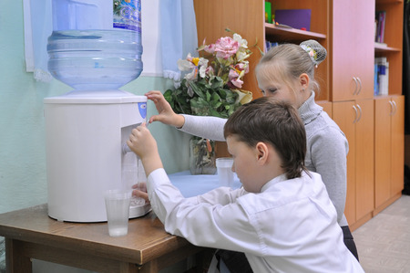 Children collect water from the coolerのeditorial素材