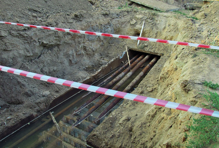 Water pipes need to be repaired are in a trench at the houseの写真素材