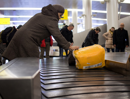 Moscow, Russia - November 07, 2015: People pick up luggage from the conveyor belt conveyor to Sheremetyevo airportのeditorial素材