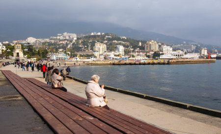 Yalta, Russia - November 08, 2015: People sitting on benches on the waterfront of the city of Yalta, Crimeaのeditorial素材