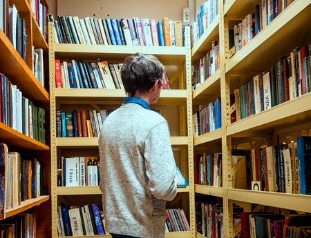 Sosnovy Bor, Russia - March 19, 2016:Library visitor stands in front of shelves with booksのeditorial素材