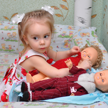 Gadjievo, Russia - April 28, 2011: Girl playing with dollsのeditorial素材