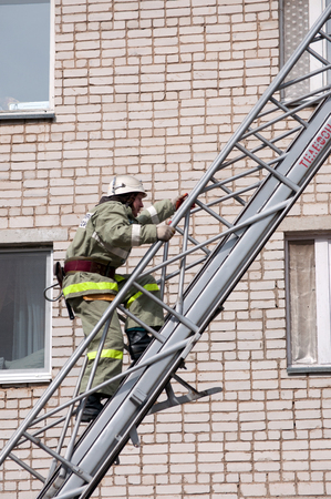 Yartsevo, Russia - August 26, 2011: The rescuer rises up the fire escape to a multi-storey buildingのeditorial素材