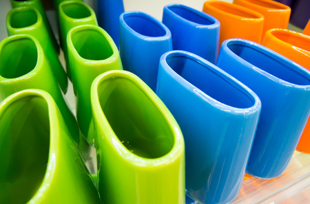 Multi-colored ceramic toothbrush stands on the shelfの写真素材