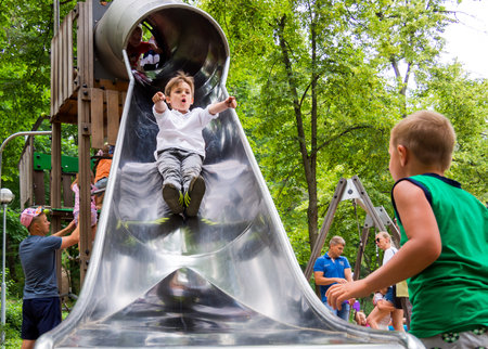 Voronezh, Russia - June 24, 2018: Boys ride on the slide of the playgroundのeditorial素材