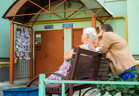 Voronezh, Russia - June 27, 2018: Bored pensioners sitting on a bench at the entranceのeditorial素材
