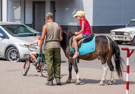 Voronezh, Russia - August 12, 2018: Riding children on horseback in the modern metropolisのeditorial素材