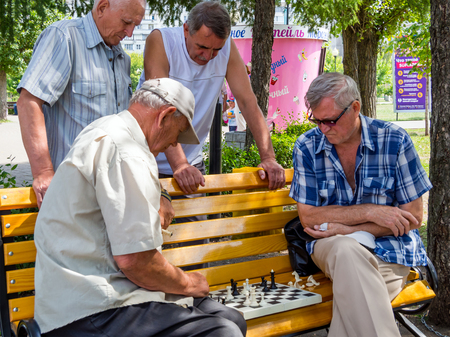 Voronezh, Russia - August 12, 2018: Chess game takes place on a park bench with the participation of spectatorsのeditorial素材