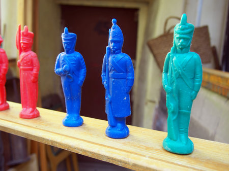 Old plastic toy soldier of the USSR stands on a wooden shelf
