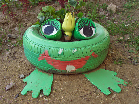 Flower bed in the shape of a frog, made from old tiresの写真素材
