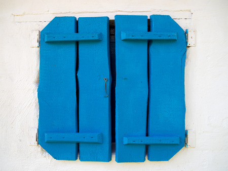 Bright vintage blue wooden shutters on the windowの写真素材