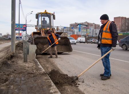 Voronezh, Russia - March 15, 2019: Cleaning the sand on the side of the road by workers of the improvement serviceのeditorial素材