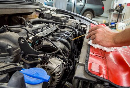 Voronezh, Russia - May 30, 2019: Auto mechanic checks engine oil levelのeditorial素材