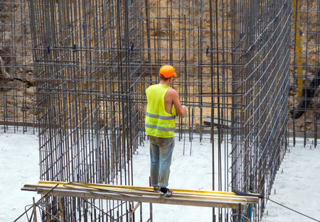 Voronezh, Russia -  June 11, 2019: Reinforcer at a construction site carries out the binding of the...