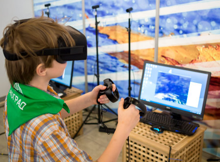 Voronezh, Russia -  June 05, 2019: A teenager in virtual reality glasses plays a computer game