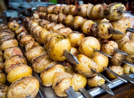 Grilled fresh potato tubers strung on skewersの写真素材