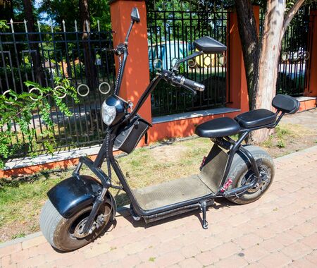 Kabardinka, Russia - August 04, 2019: A small electric scooter is parked on the sidewalkのeditorial素材