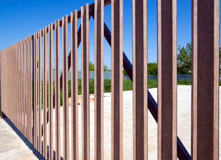 Fragment of a fence made of metal picket stripsの写真素材