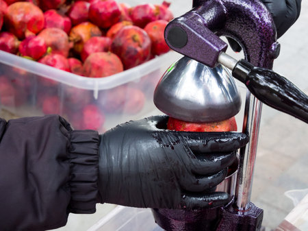 Making pomegranate juice with a hand press