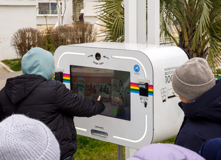 Sochi, Russia - February 23, 2023: People at an instant photography machine on the Sochi embankment