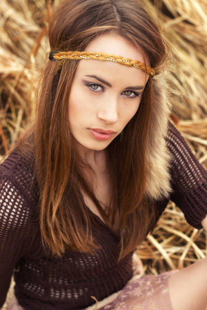 beautiful girl hippies sitting in the dry grassの写真素材