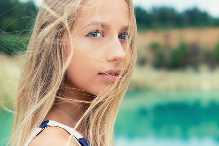 portrait of beautiful sexy girls with full lips and blond hair stands near the lakeの写真素材