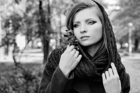 beautiful woman with Rowan in hand with the beautiful makeup with a scarf on her head walks in the Park in autumn Sunny dayの写真素材