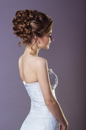 Portrait of a beautiful gentle and elegant girl women bride in a white dress with a beautiful hairstyle and makeupの写真素材