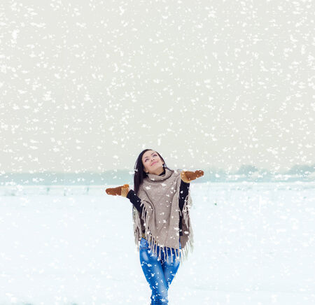 beautiful happy smiling girl woman walking in a field on a winter evening, and happy snowの写真素材