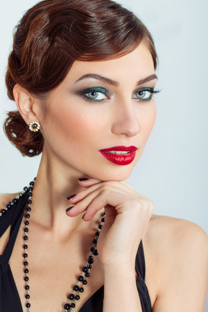 Beautiful young sexy woman with evening makeup and hair, with red lipstickの写真素材