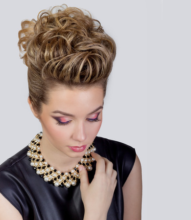 Beautiful young woman with evening make-up and salon hairdo . Smoky eyes. Complicated hairstyle for partyの写真素材