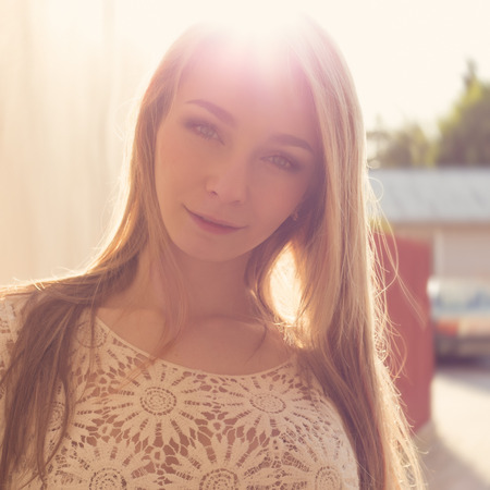 beautiful sexy tender girl near the wall, next to a wooden fence at sunset in the city, volntse hairの写真素材
