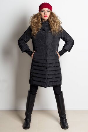 beautiful sexy girl with bright makeup posing in the coat in the studio on a white background, shot for the catalogの写真素材