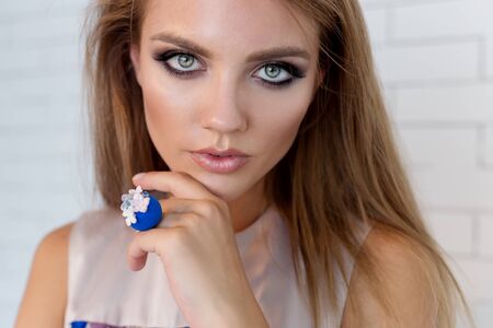 fashion portrait of beautiful young girl with a bright evening make-up for an evening look with beautiful bright jewelryの写真素材