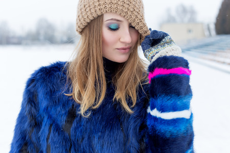 Beauty Fashion model girl in a fur coat Beautiful brunette woman with bright makeup in bright winter dayの写真素材