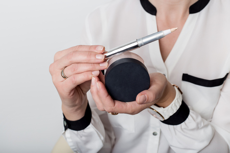 beautiful woman shows a decorative cosmetic products in jarsの写真素材