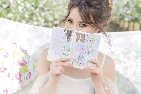 beautiful sweet gentle happy girl in a beige boudoir dress with flowers in a basket holding, photo processing in the style of modern fine artの写真素材