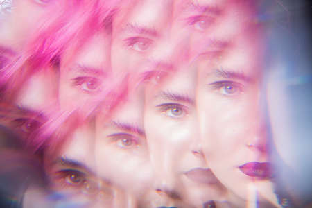 fashion shot of a girl with pink hair in a pink dress on a black background in the studio, girl hipster, youth fashionの写真素材