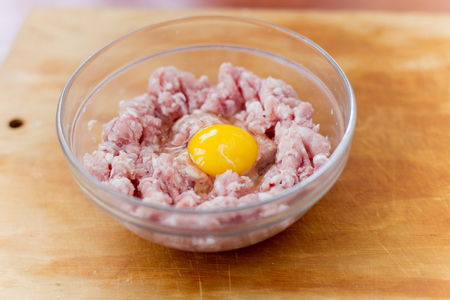 Cooked fresh mince for dish with raw egg lie in a plateの写真素材