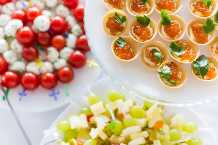 A small table with a delicious buffet of canapes, caviar, sandwichesの写真素材