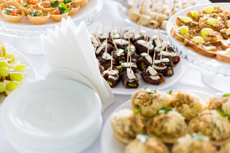 A small table with a delicious buffet of canapes, caviar, sandwichesの写真素材