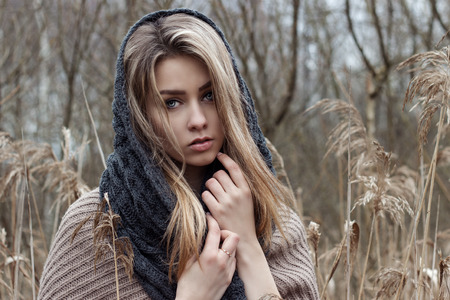 beautiful sad girl is walking in the field. Photo in brown tones.の写真素材