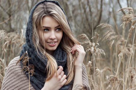 beautiful sad girl is walking in the field. Photo in brown tones.の写真素材