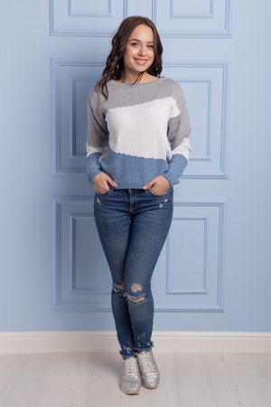 beautiful cute girl with a smile demonstrates knitted clothesの写真素材